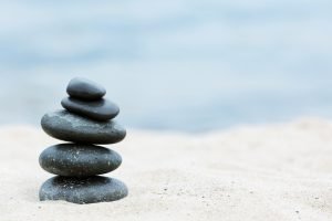 Image of stones balanced on the sand