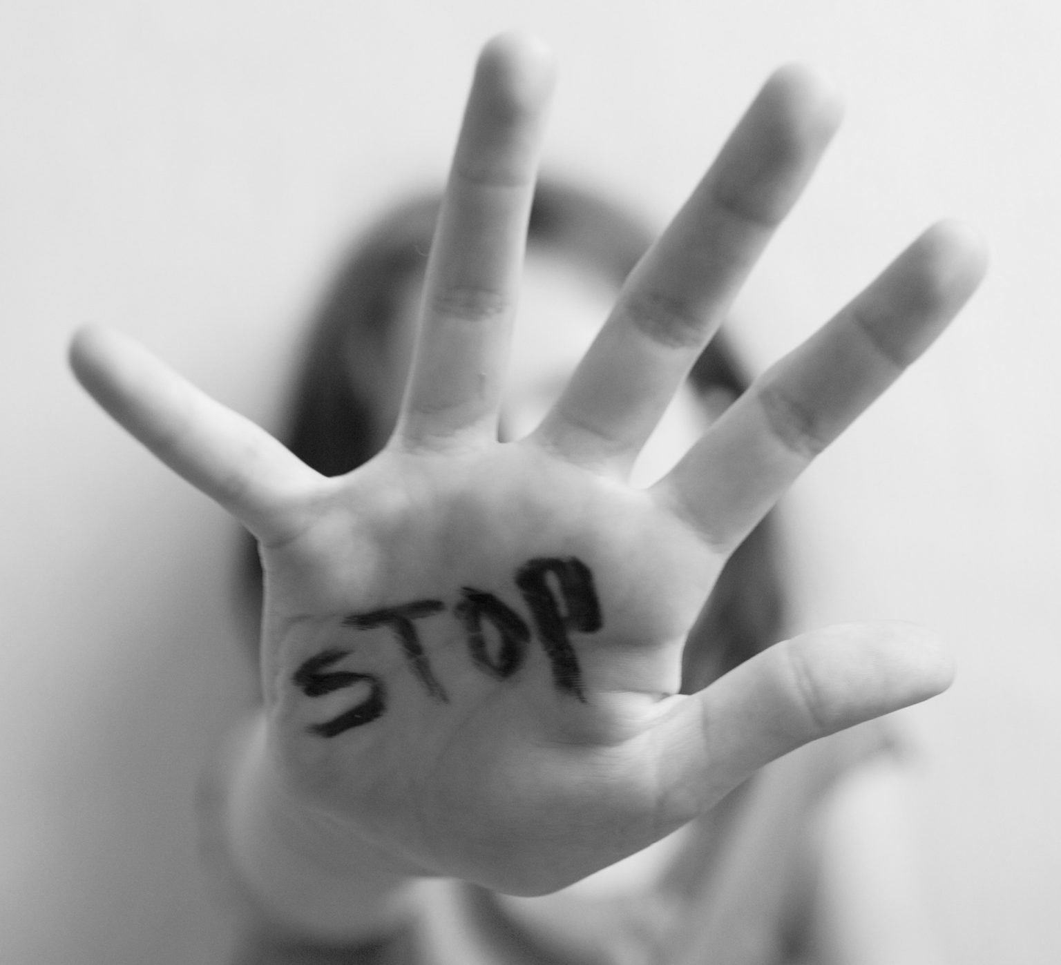 Hand spread with STOP written in black ink representing LifeRing meeting for people surviving domestic violence